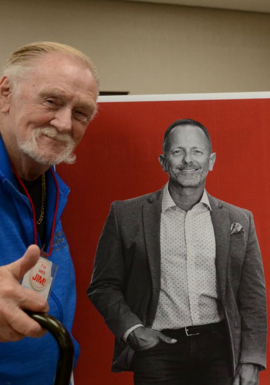 Colonel Hank Handke standing beside a Jim Diodati for Mayor campaign sign, giving a thumbs-up